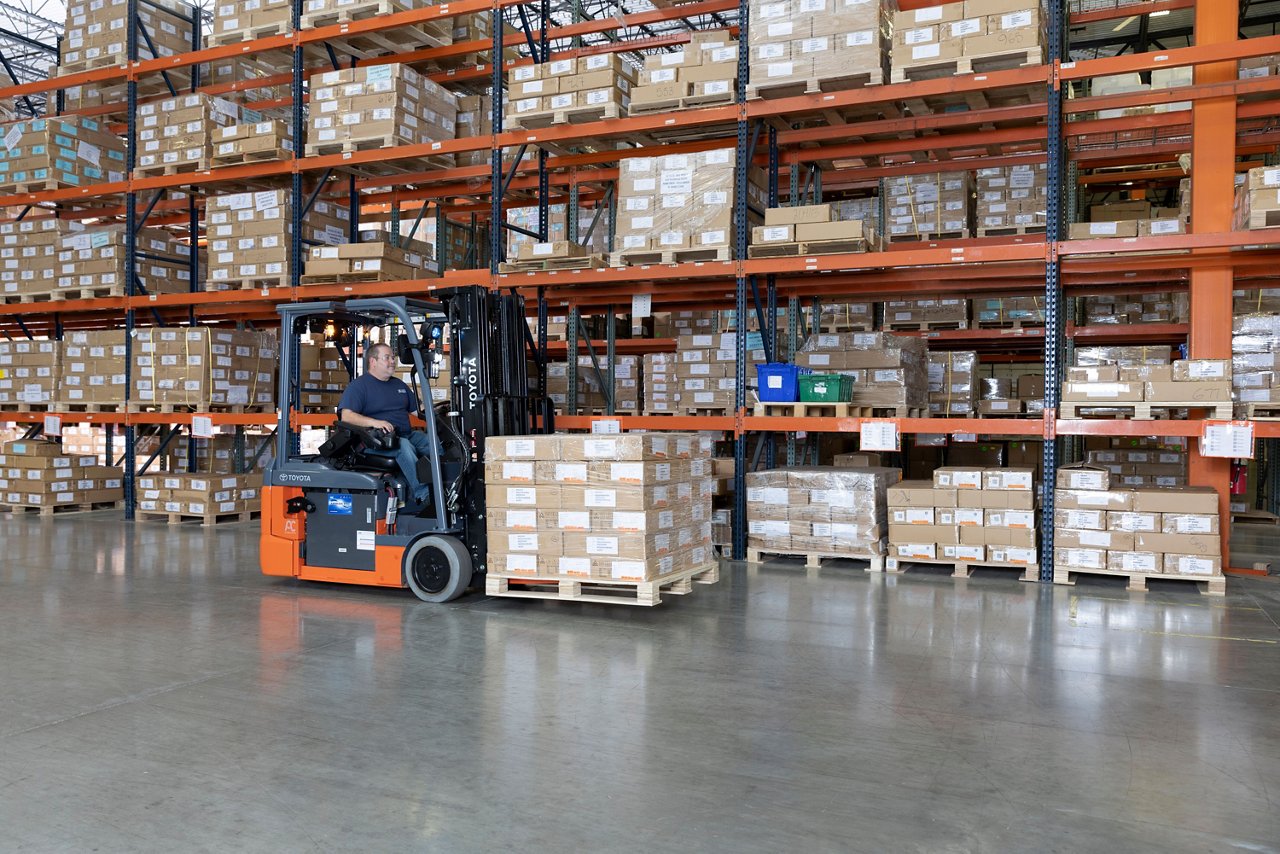 3-wheel electric forklift lifting a pallet 