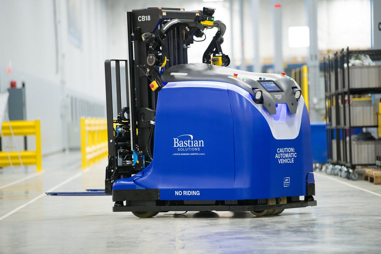 Gran carretilla elevadora automatizada azul utilizada para transportar cargas pesadas a través del almacén o centro de distribución
