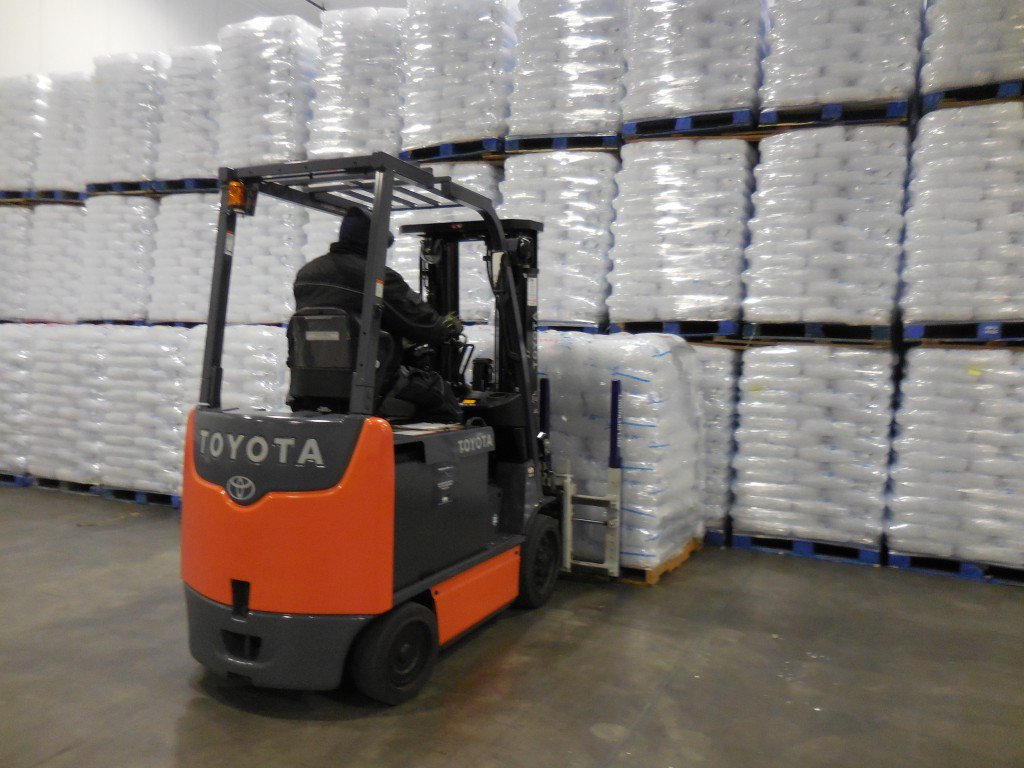 Toyota forklift loading a stack of boxes of ice in a warehouse 