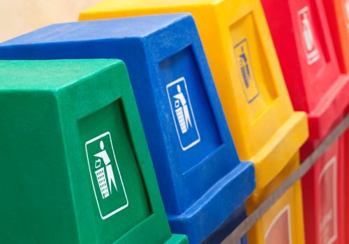 4 different colored recycling bins lined up next to each other
